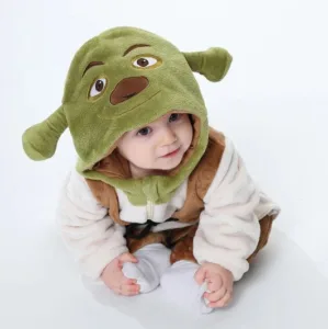 En detaljerad Shrek-maskeraddräkt för barn, som inkluderar en heldräkt med gröna rutiga byxor, en ljus överdel med en brun väst och en grön mössa med de ikoniska Shrek-öron.