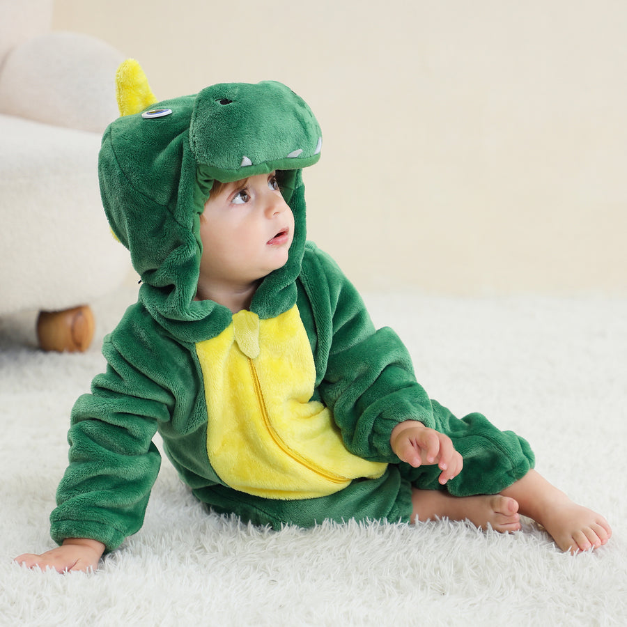 En mjuk och gullig grön T-Rex maskeraddräkt för barn, gjord av bekvämt flanellmaterial. Dräkten har en rolig huva med dinosaurieansikte och vita tänder samt en liten svans baktill.