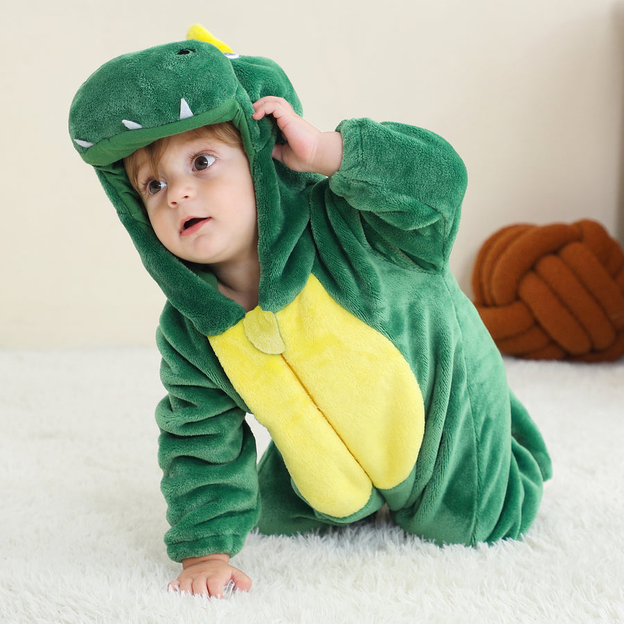 En gullig och mjuk grön T-Rex dinosauriedräkt för barn, som visas från sidan. Dräkten är gjord av bekvämt flanellmaterial med taggiga ryggsköldar, en lång svans och en huva med ögon och tänder, perfekt för lek eller maskerad.