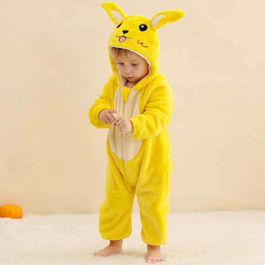 En bild av en gullig och mjuk gul Pikachu-maskeraddräkt för barn, formad som en heldräkt i fleece. Dräkten har en huva med Pikachus ansikte och de karakteristiska långa öron med svarta spetsar, samt två bruna ränder på ryggen och en dragkedja framtill.