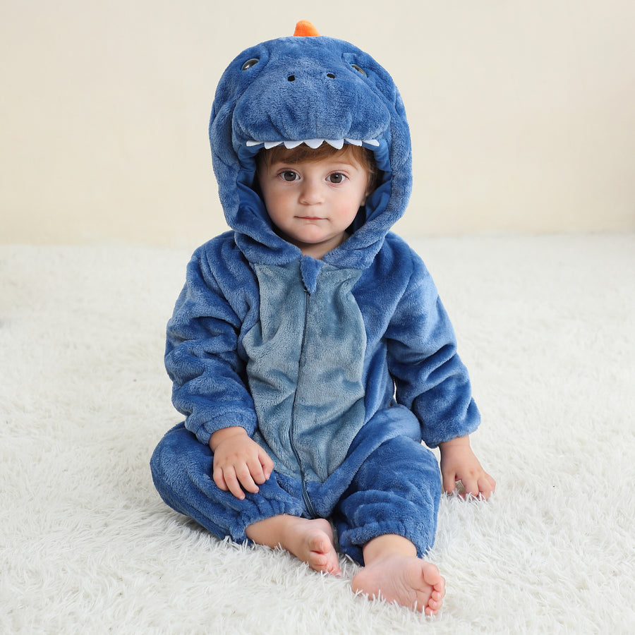 Bilden visar en charmig och mjuk blå T-Rex maskeraddräkt för barn, sett från sidan. Dräkten är gjord av lurvig flanell med en vit mage, taggar längs ryggen och en matchande huva med ett sött dinosaurieansikte, vilket gör den perfekt för både lek och maskerad.