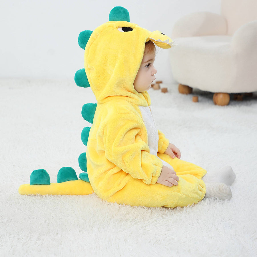 En charmig och mjuk gul T-Rex maskeraddräkt för barn, formad som en heldräkt i lurvig flanell. Dräkten har en vit mage, en detaljerad huva med ett sött ansikte och tänder, samt taggar på ryggen och en liten svans baktill.